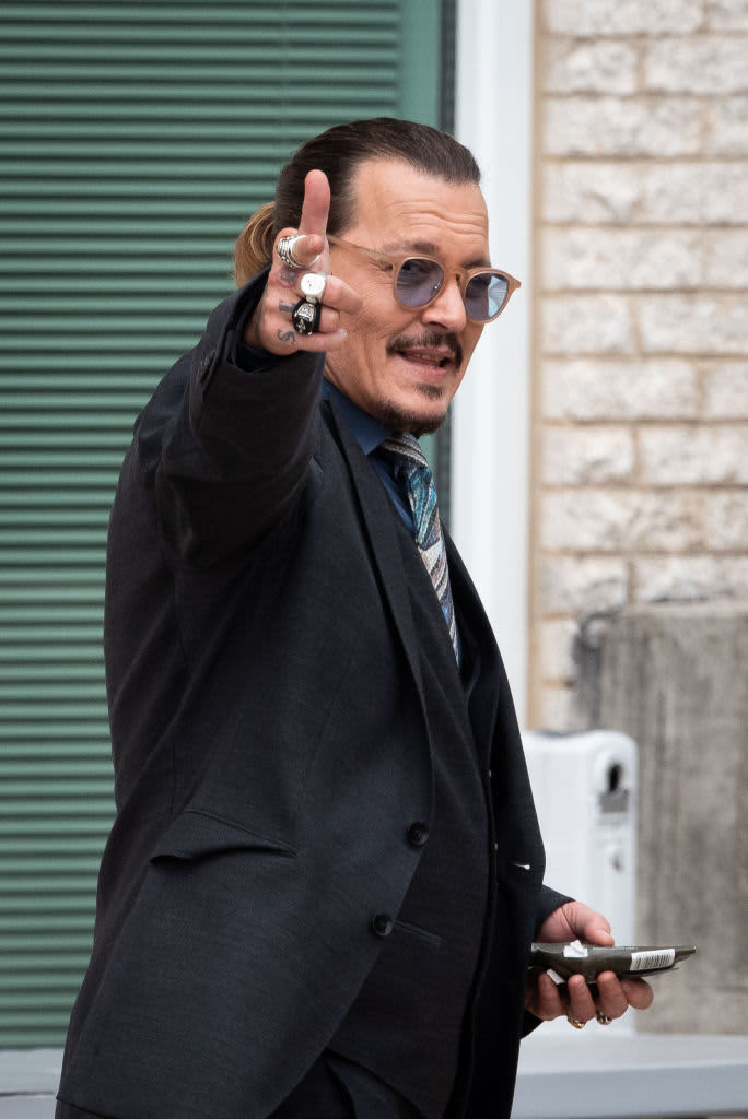 FAIRFAX, VA - May 25: (NY & NJ NEWSPAPERS OUT) Johnny Depp gestures to his fans outside court during the Johnny Depp and Amber Heard civil defamation trial at Fairfax County Circuit Court on May 25, 2022 in Fairfax, Virginia. Depp is seeking $50 million in alleged damages to his career over an op-ed Heard wrote in the Washington Post in 2018.(Photo by Cliff Owen/Consolidated News Pictures/Getty Images)