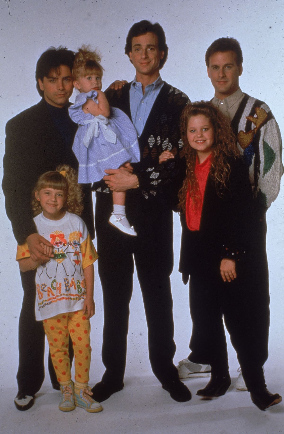 Portrait of the cast of the television program, 'Full House,' (left - right): John Stamos, Jodie Sweetin, Ashley or Mary-Kate Olsen, Bob Saget, Candace Cameron, and David Coulier, c. 1989. (Photo by Fotos International/Getty Images)