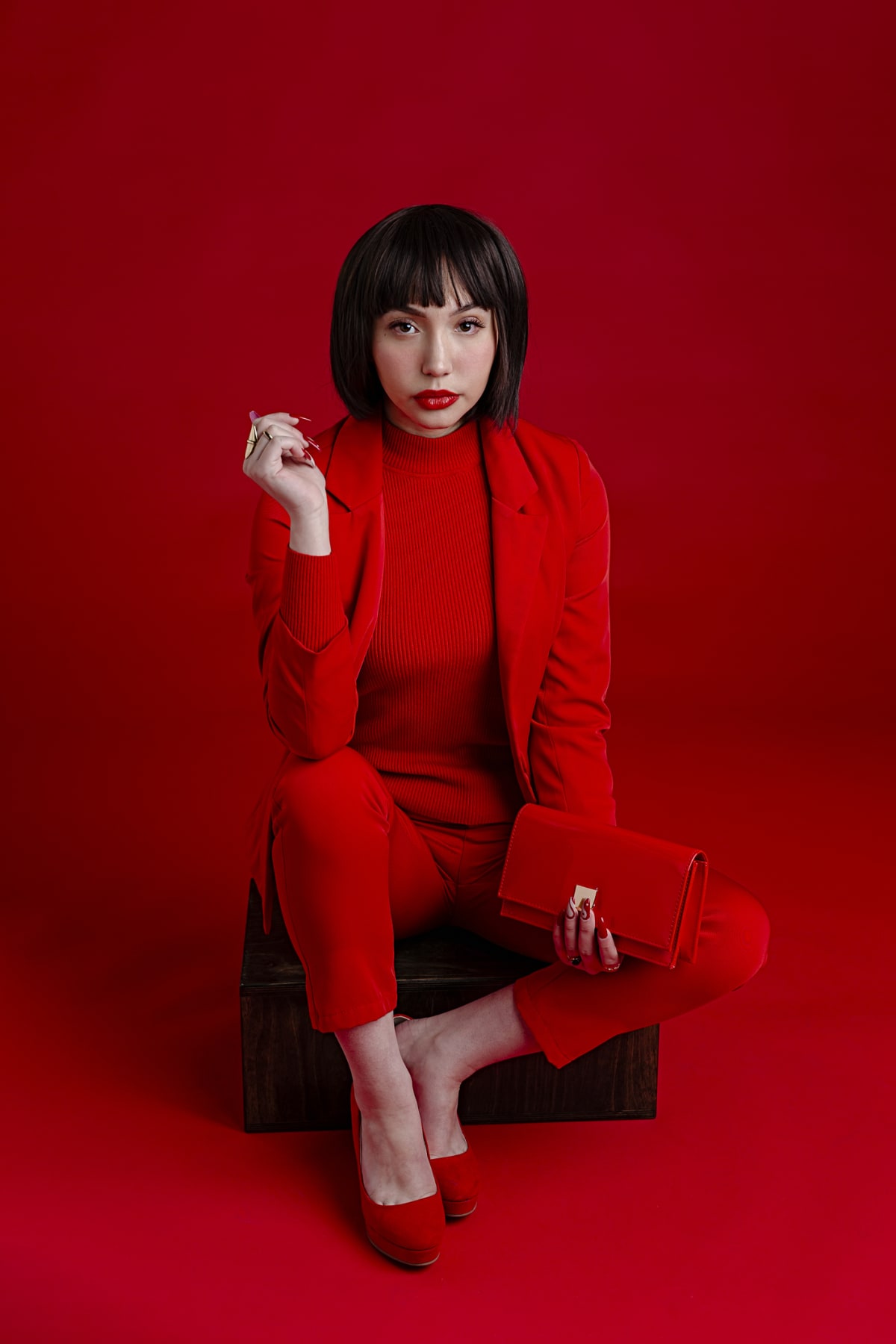 Woman wearing an all red ensemble against a red background