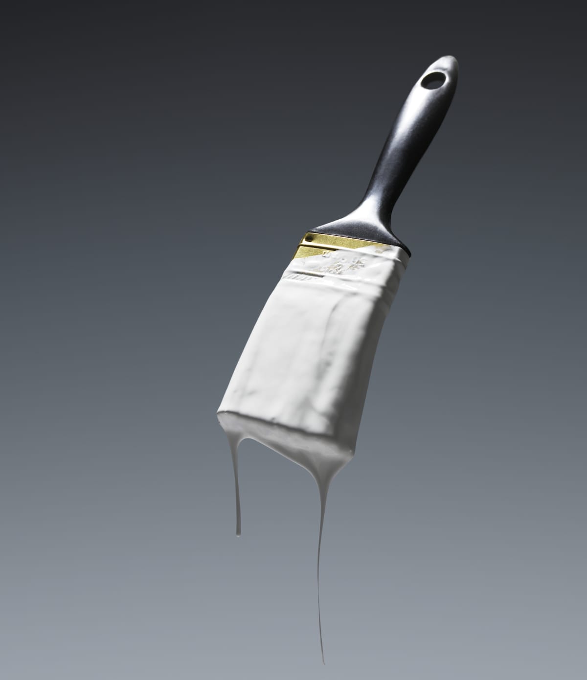 A paintbrush dripping white paint