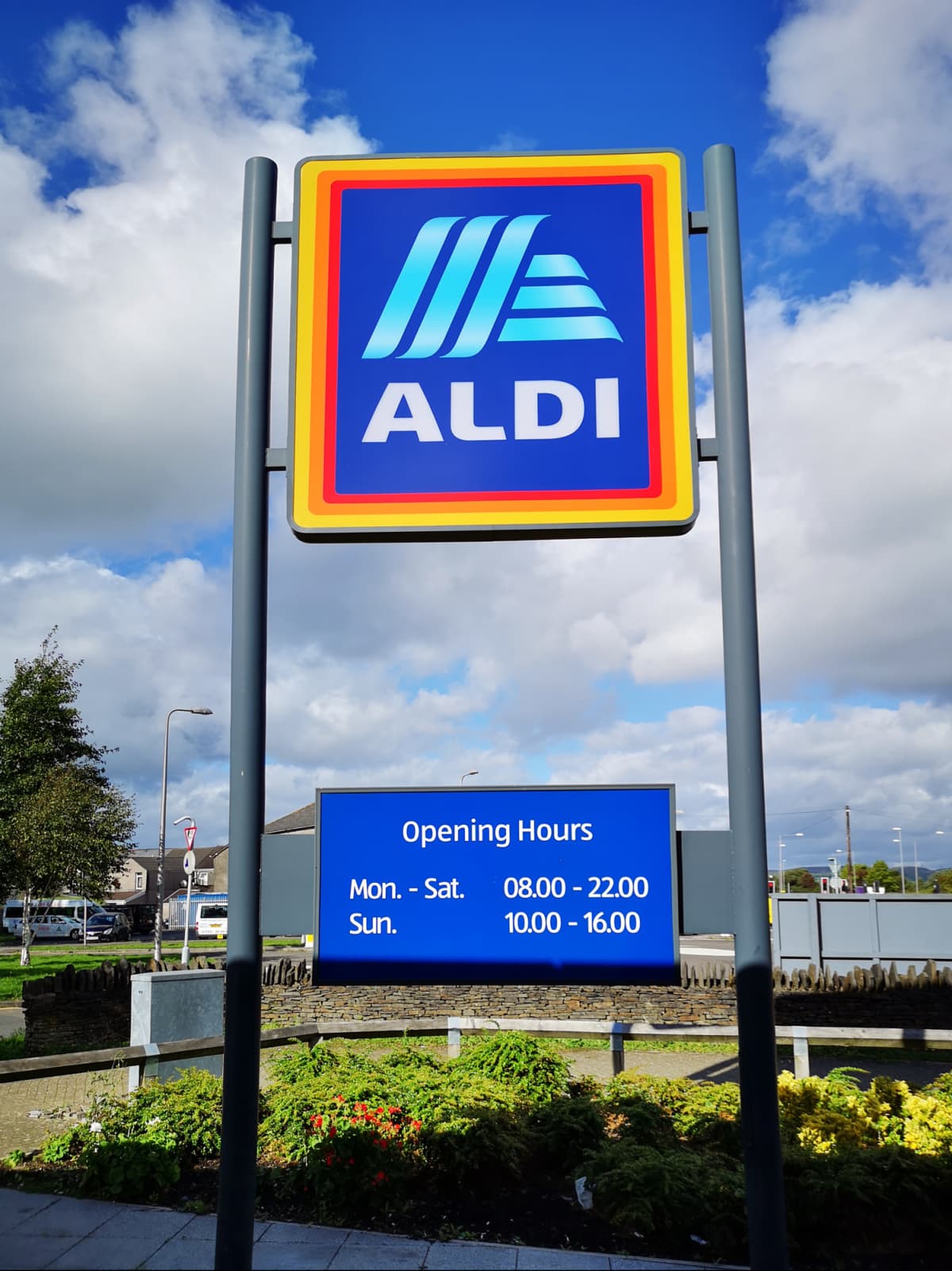 Aldi shop sign with opening hours against blue sky, Martlesham Heath, Suffolk, England, UK. (Photo by: Geography Photos/UCG/Universal Images Group via Getty Images)