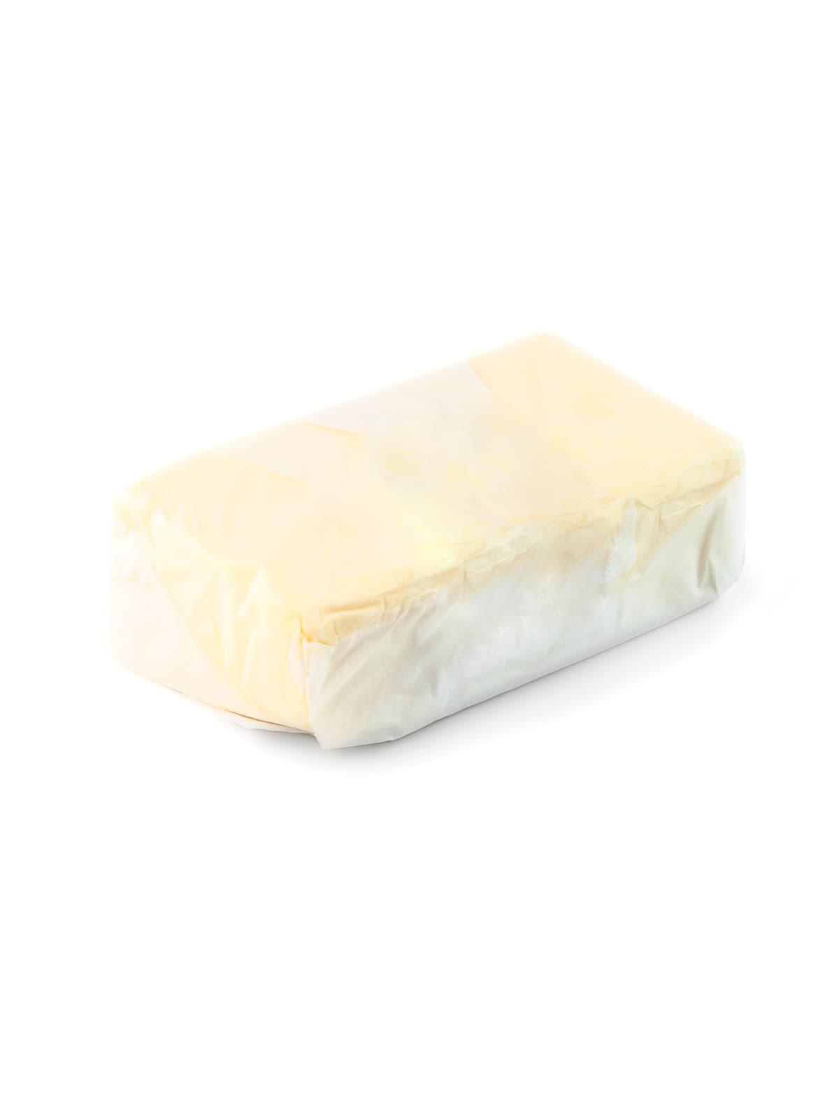 Block of butter in craft paper on white background, top view