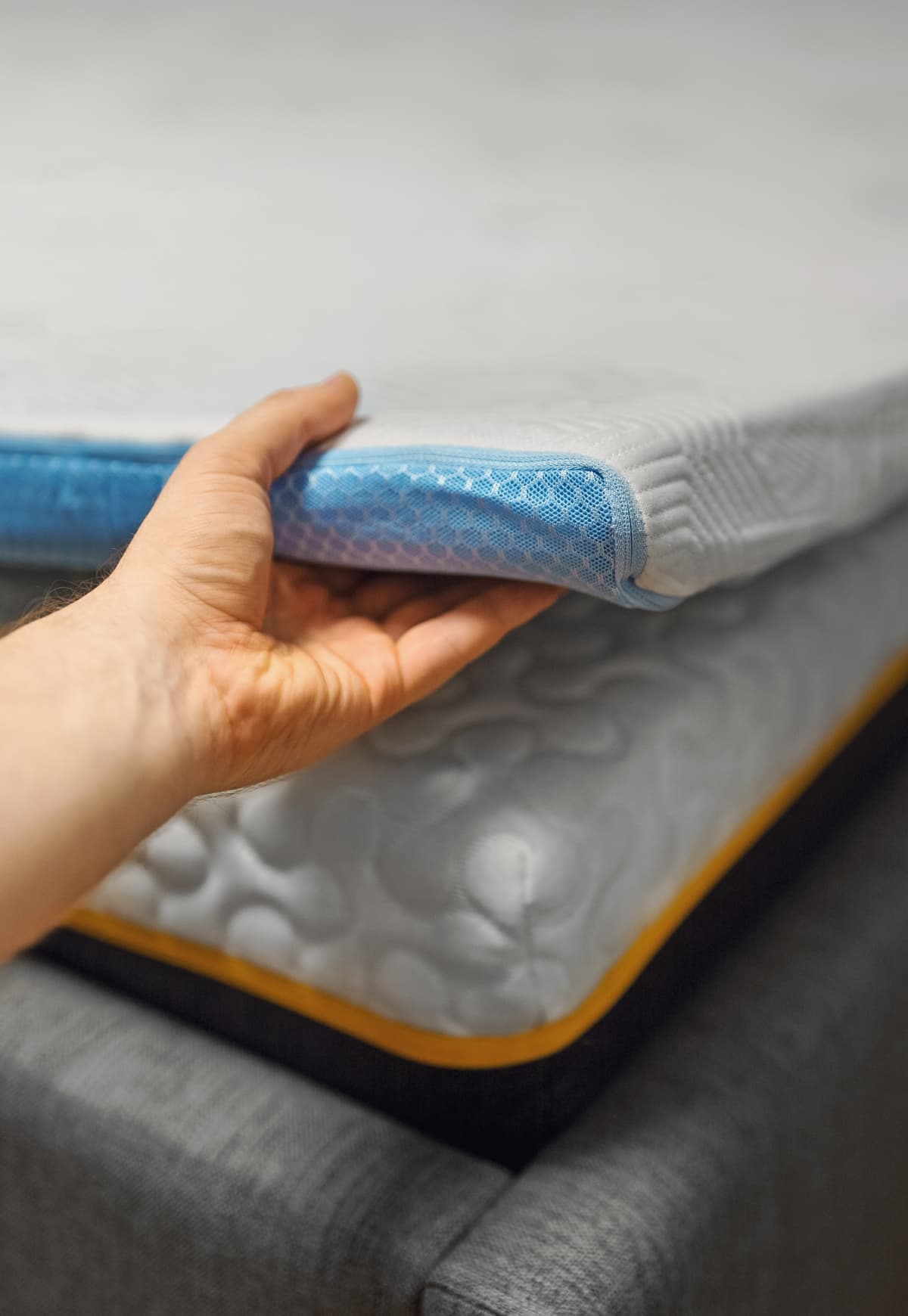 Man hand testing memory foam mattress topper.