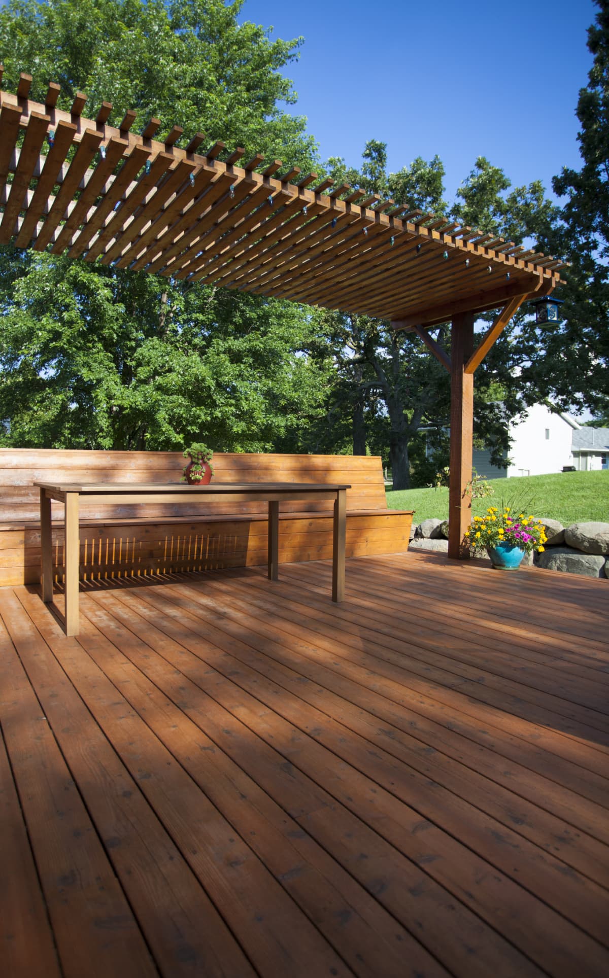 A backyard deck with a bench and a table