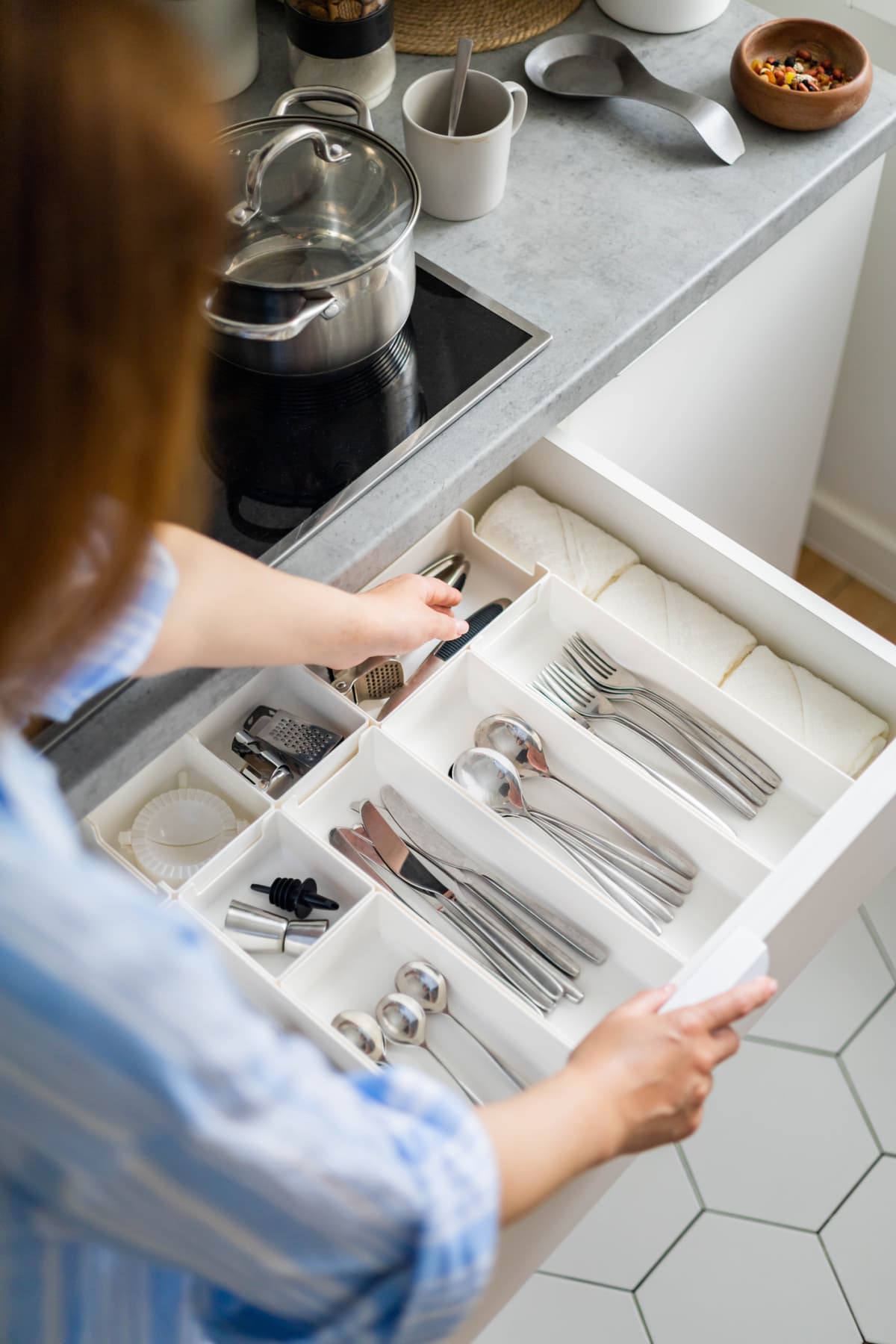 Woman tidying up cutlery in a drawer