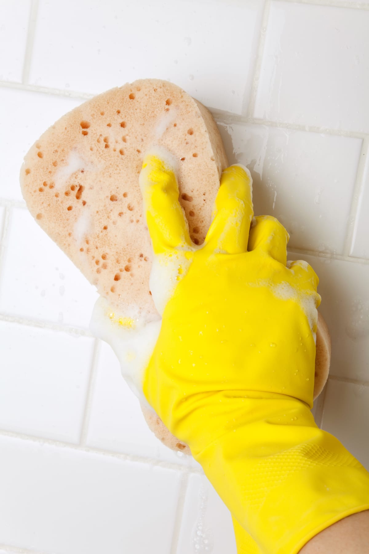 Using a sponge to clean tiles.