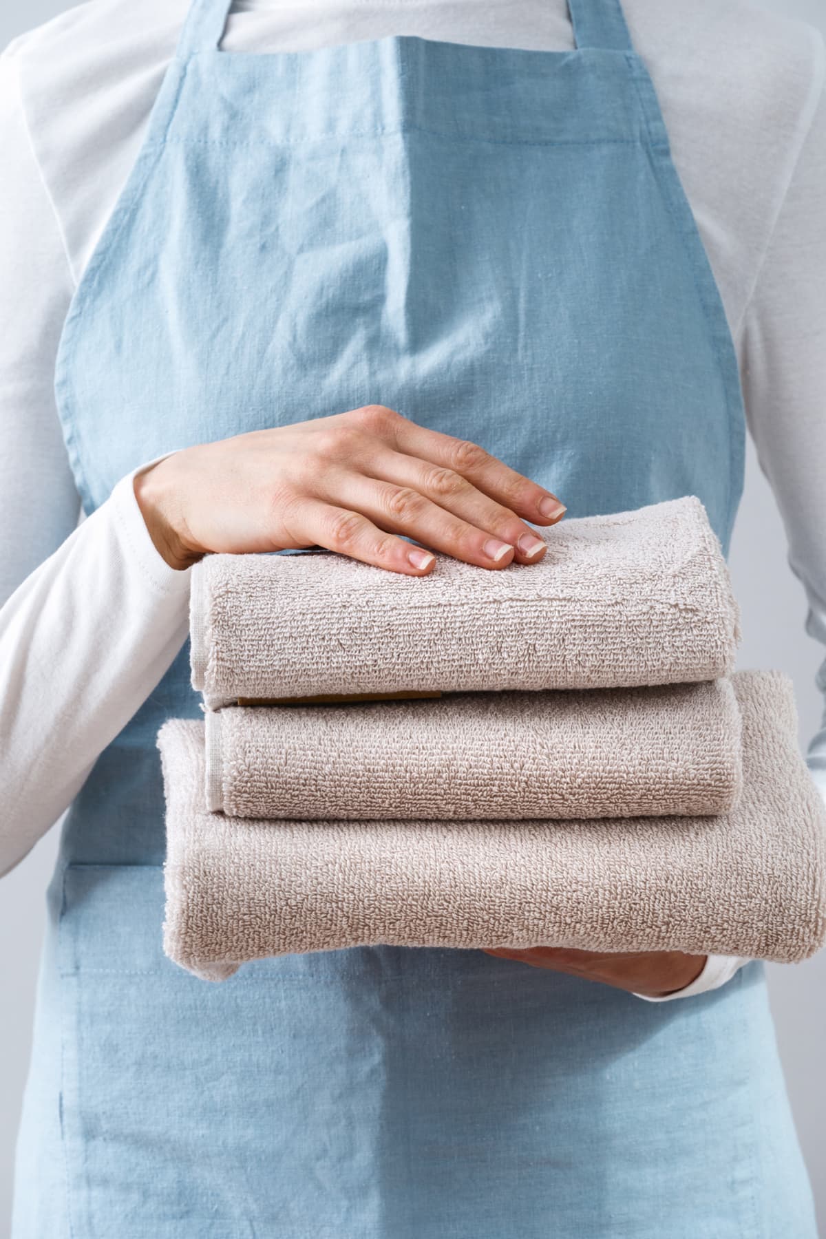 A person holding a stack of folded towels