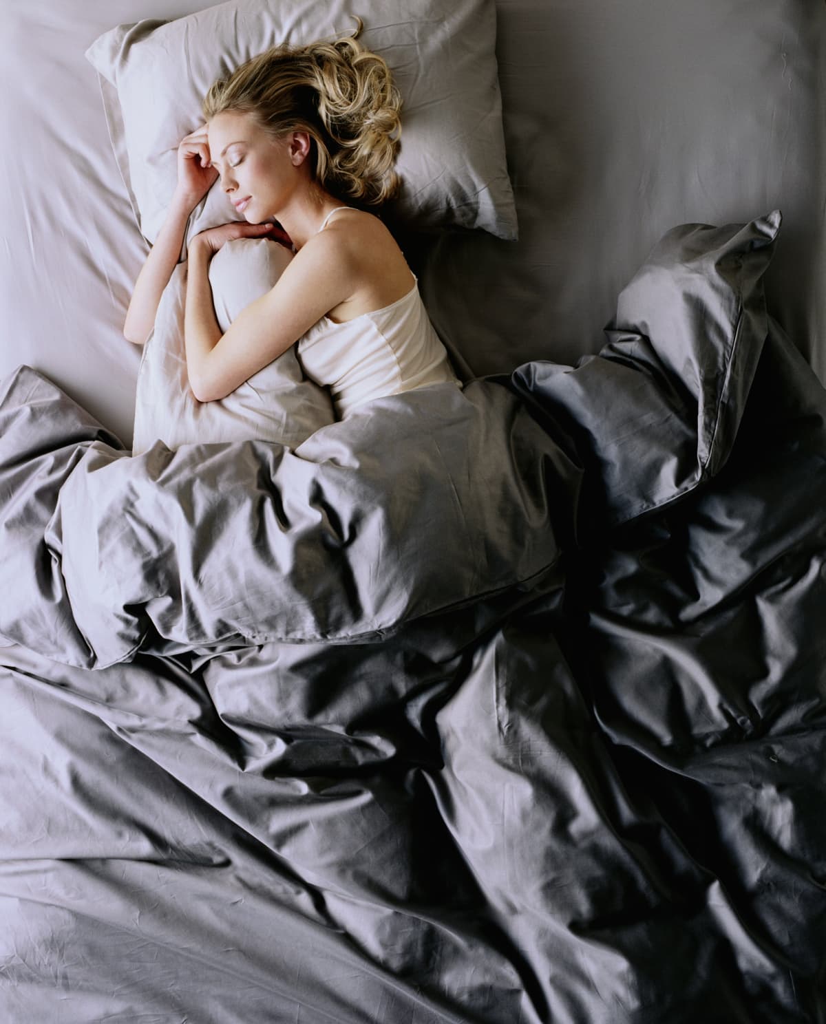 Young woman peacefully sleeping under a duvet