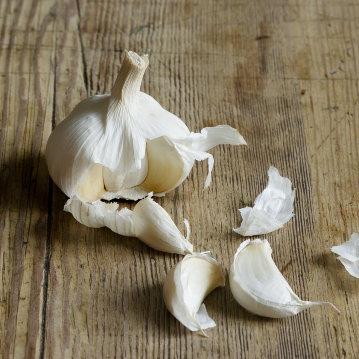 Peeled garlic cloves on wood