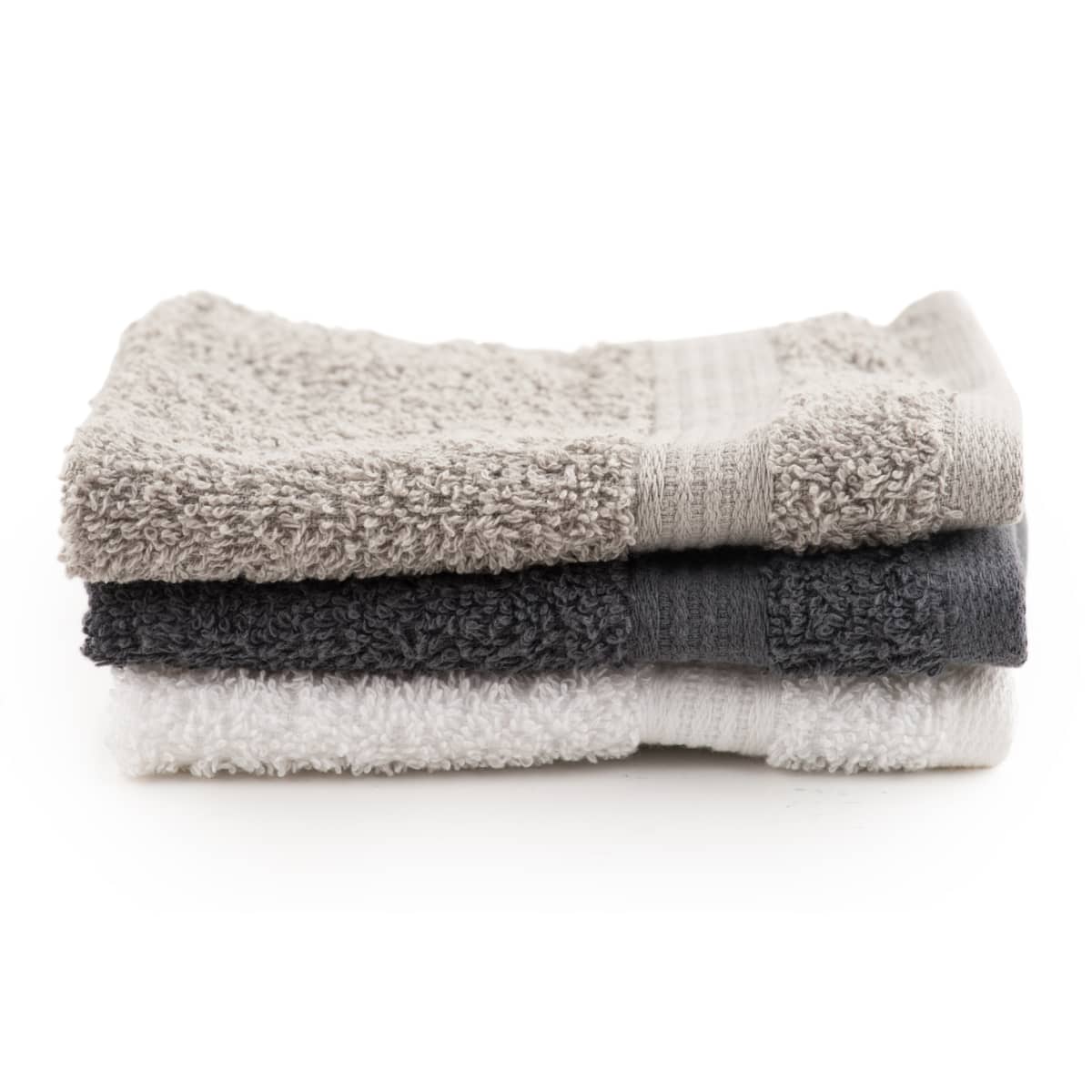 White, black, gray bath towels in stack on white background