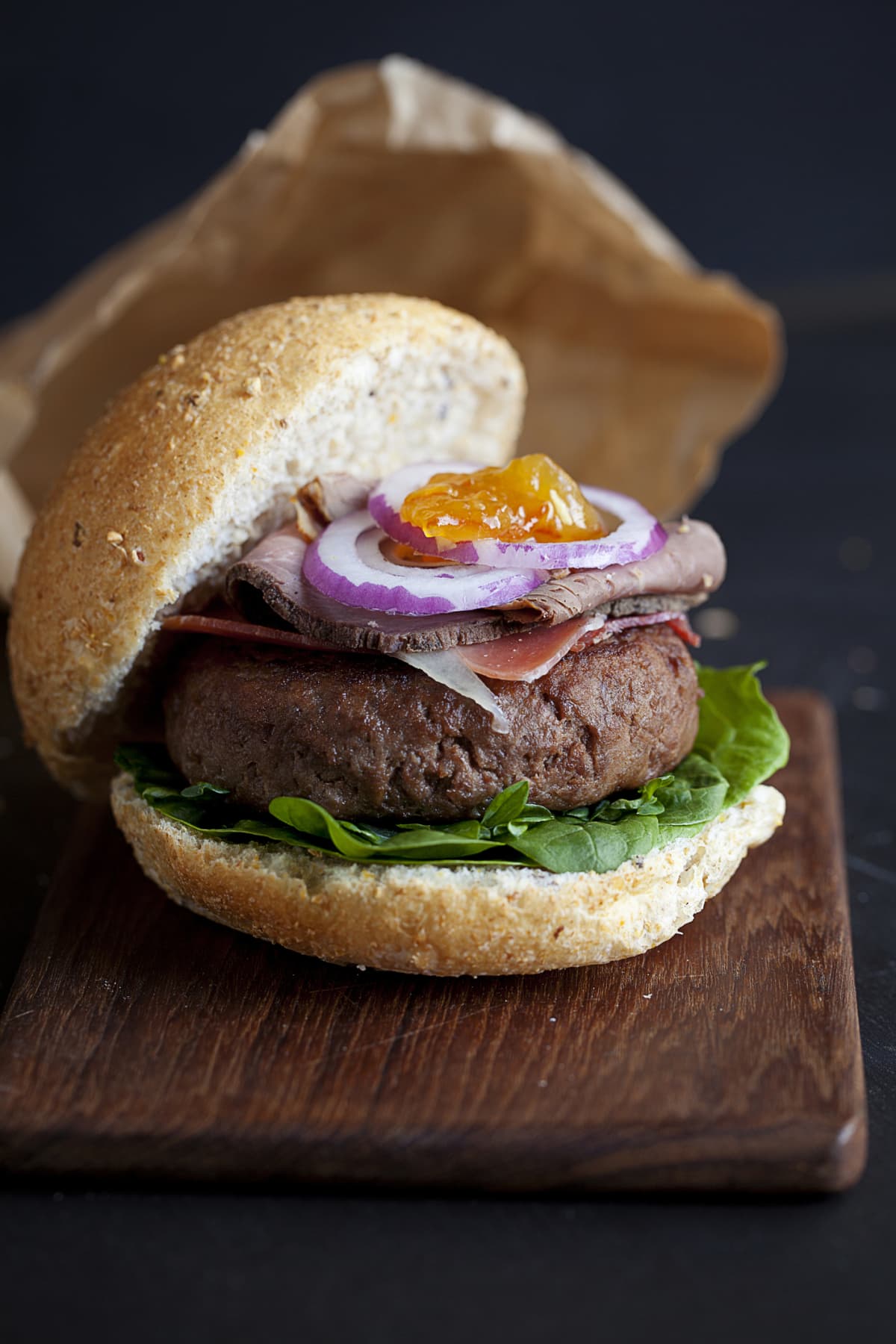 Burger with wagyu patty dressed with onion and lettuce and served on a bun