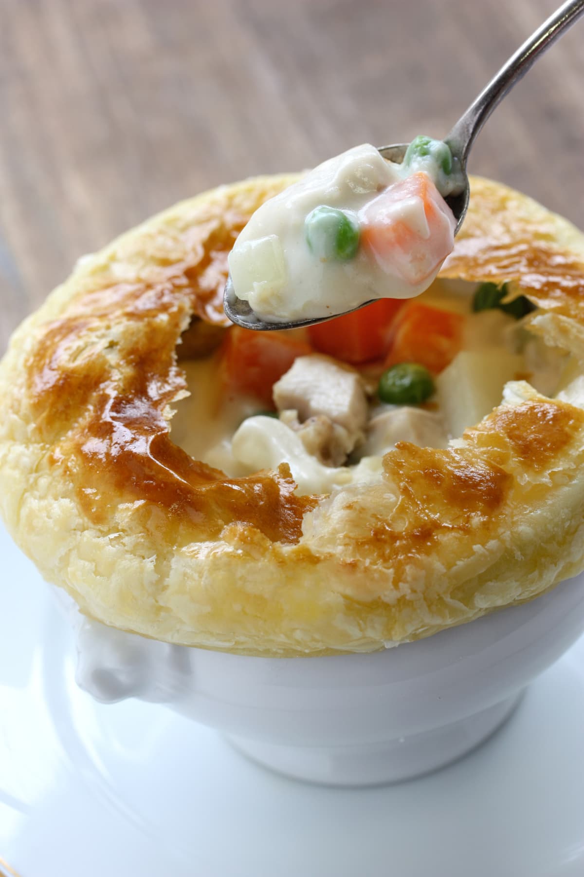 A spoon taking a portion out of a chicken pot pie.