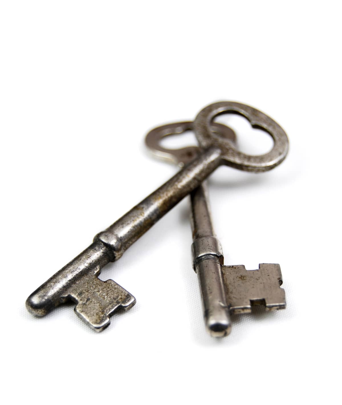 Two old fashioned skeleton keys on a white background. Unlock new doors.