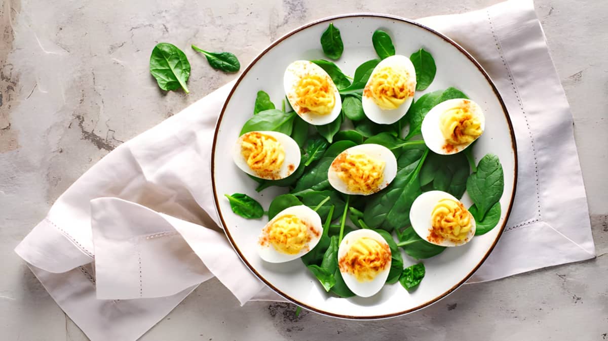 Deviled eggs on a plate with spinach