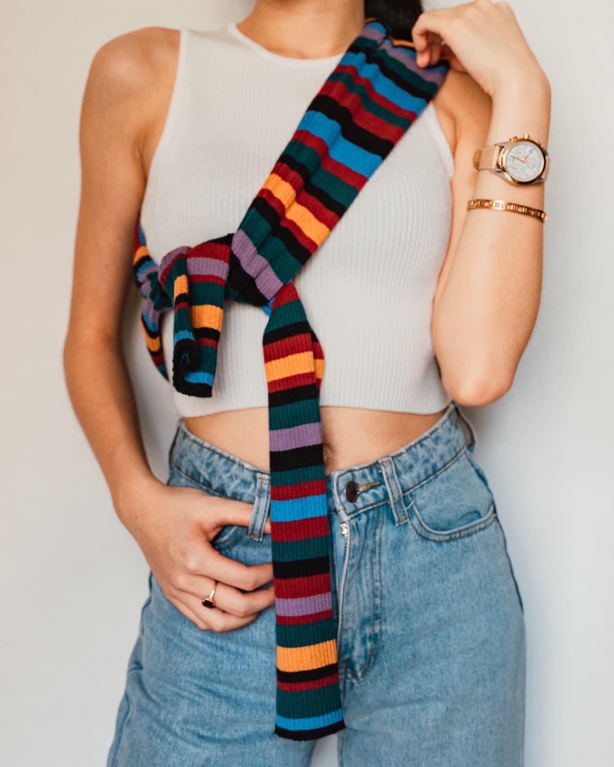 A slim woman wearing jeans shirt and a colorful scarf with stripes