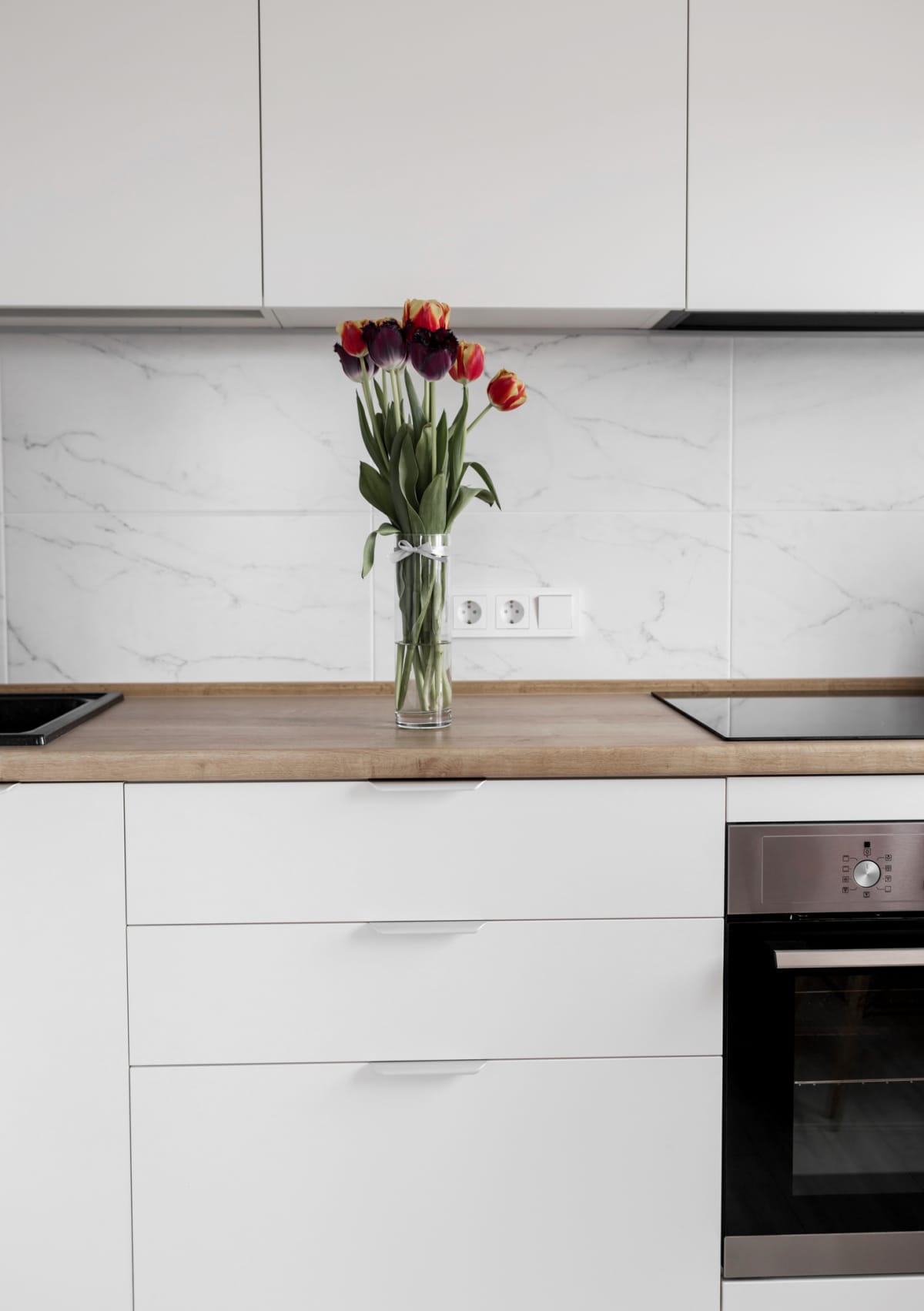 Elegant white kitchen interior featuring a marble backsplash