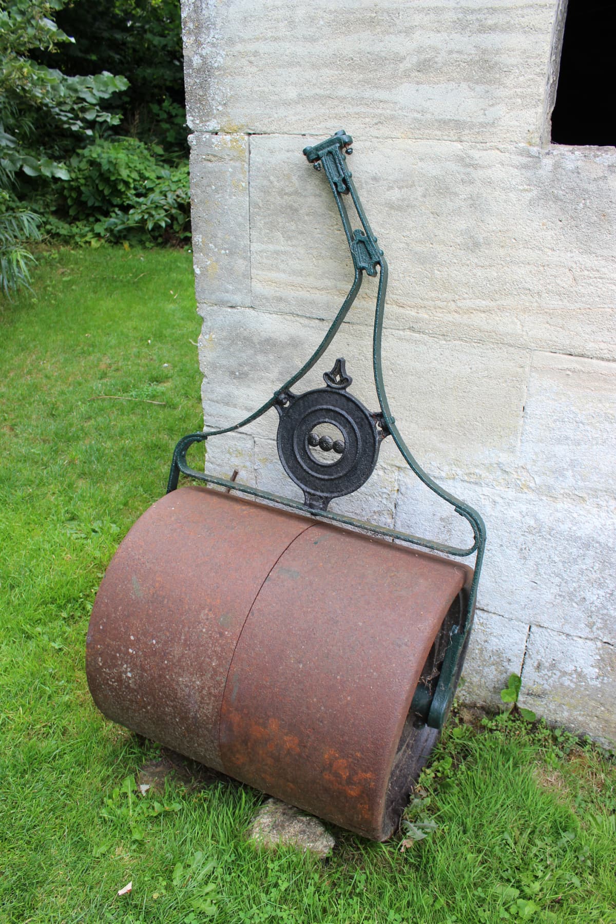 Rusty lawn roller with ornate handle