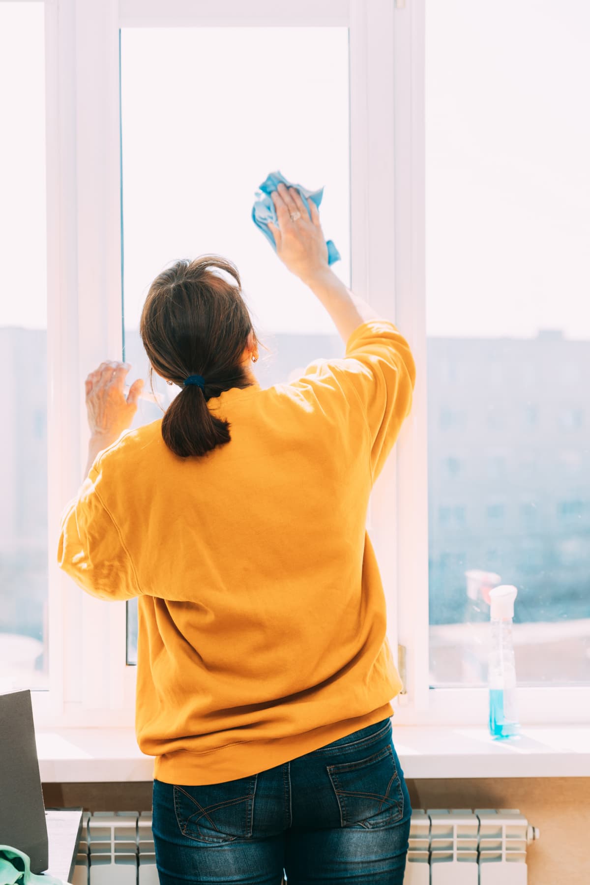 Woman cleaning her home windows