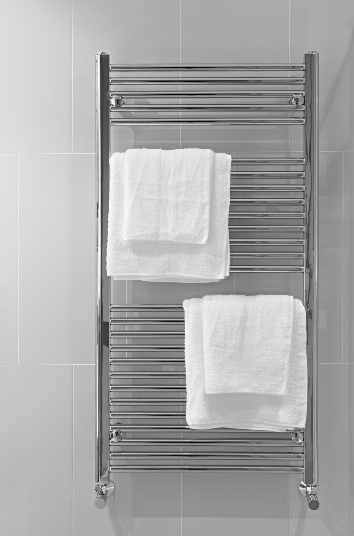 a modern chrome towel rail mounted against a tiled wall with two sets of white cotton towels. Rendered in black and white with contrast pushed slightly for effect.Looking for a Bathroom image Then please see my other Bathrooms and related inages by clicking on the Lightbox link below...A>AA>A