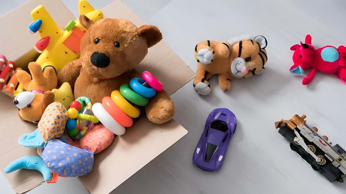 Cardboard box full of stuffed animals and assorted toys