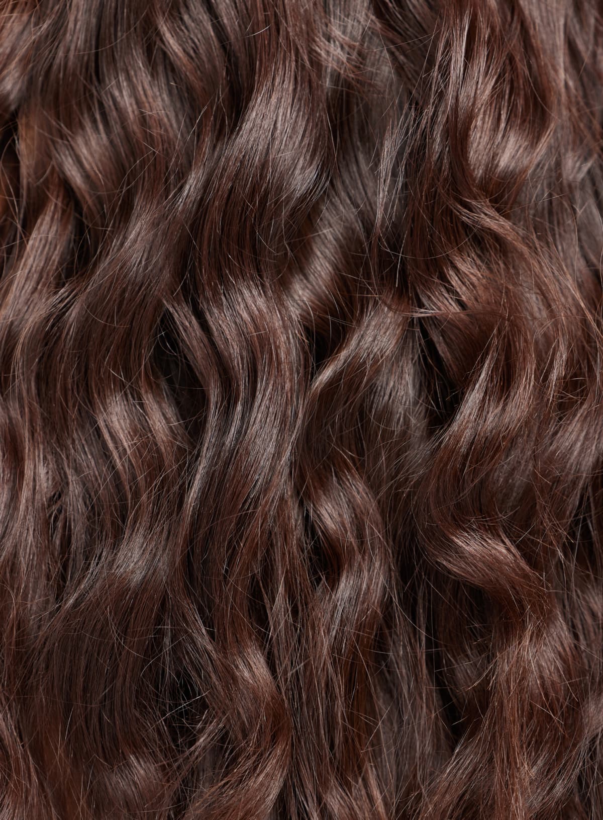 A close up of long dark hair with loose curls