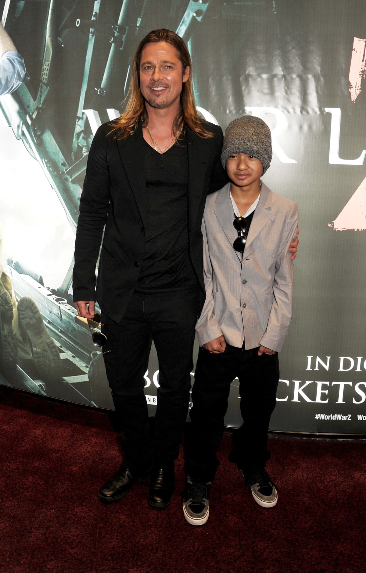 Brad Pitt at a movie premiere poses with his arm around his son, Maddox