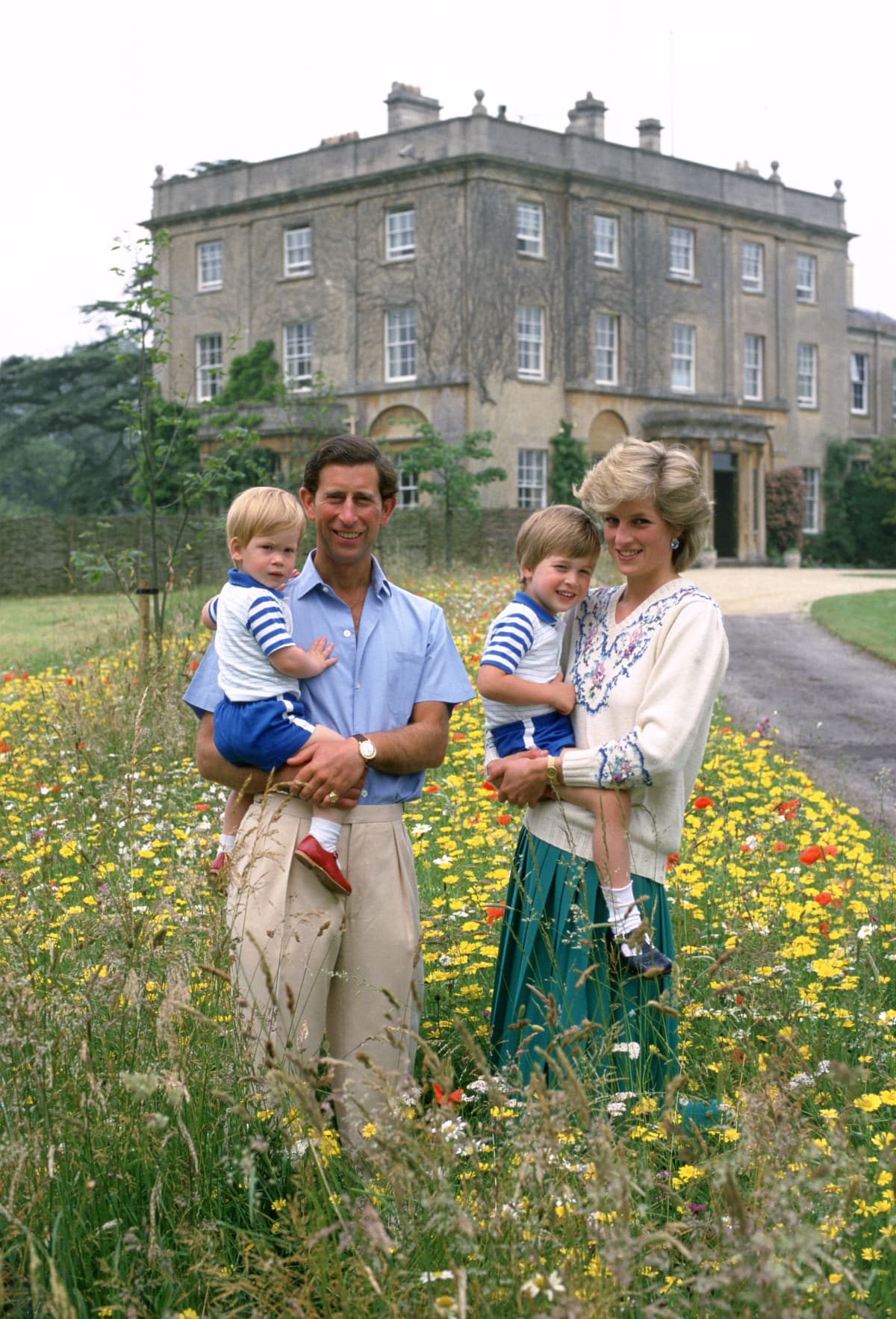 Prince Charles holding Prince Harry and Princess Diana holding Prince William outside of Highgrove House