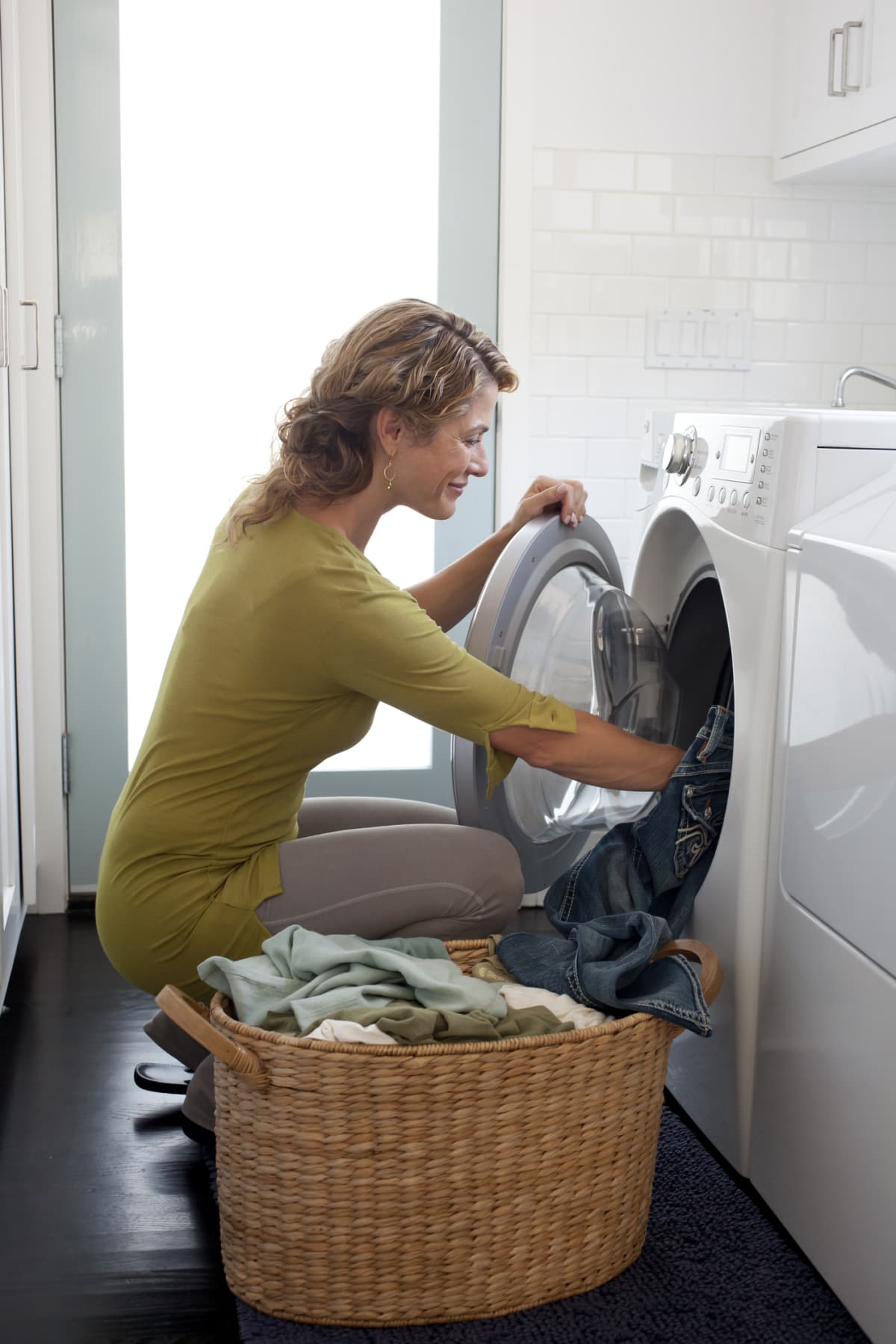 Woman putting clothes in a washer