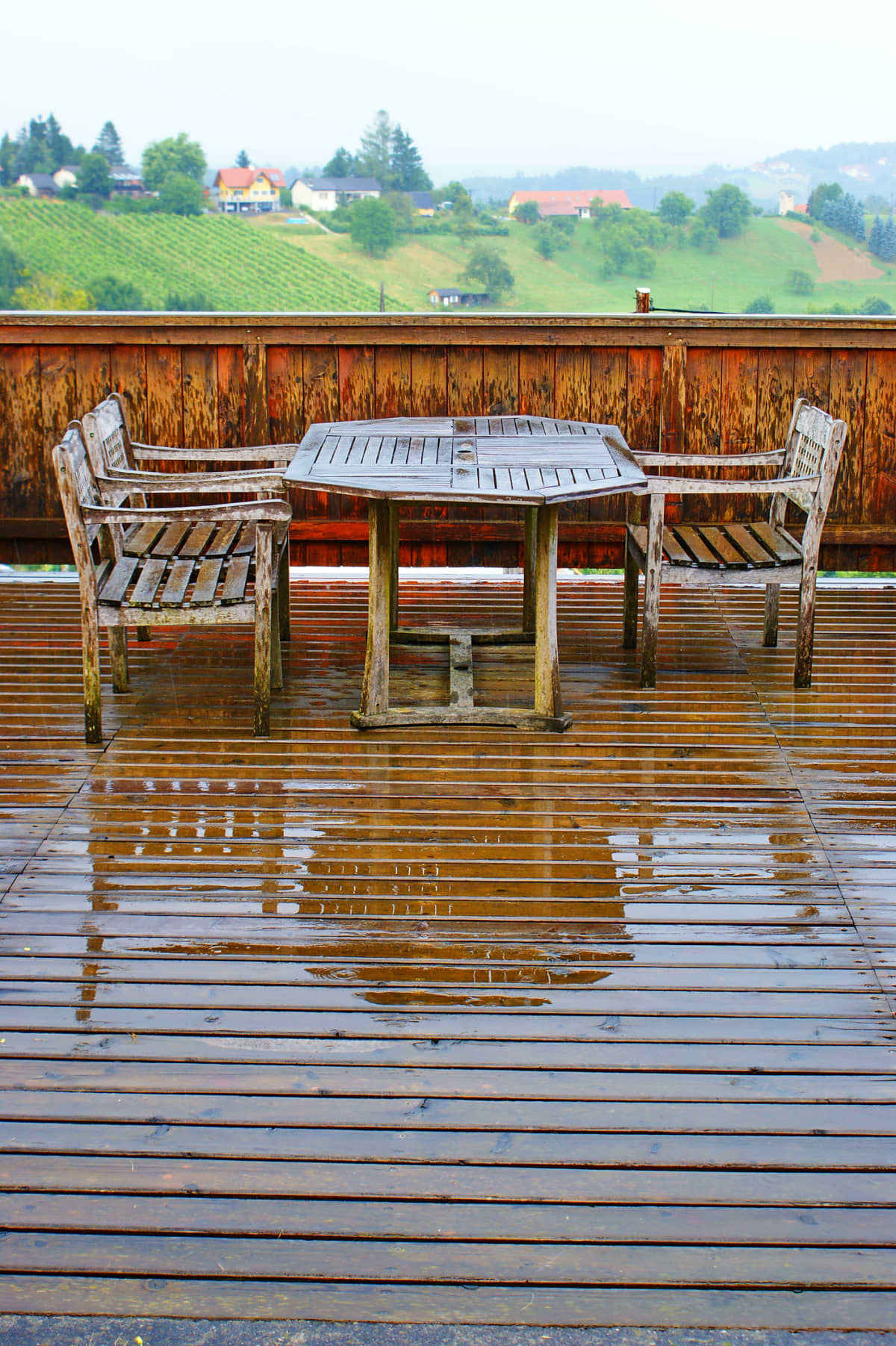 A wood deck with furniture in the rain