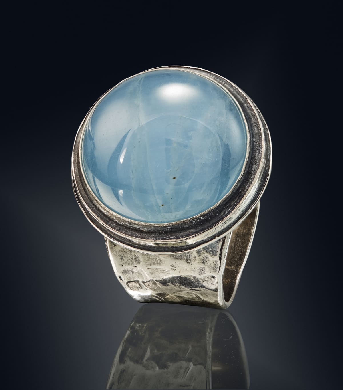 Mood ring with a blue stone on a dark background