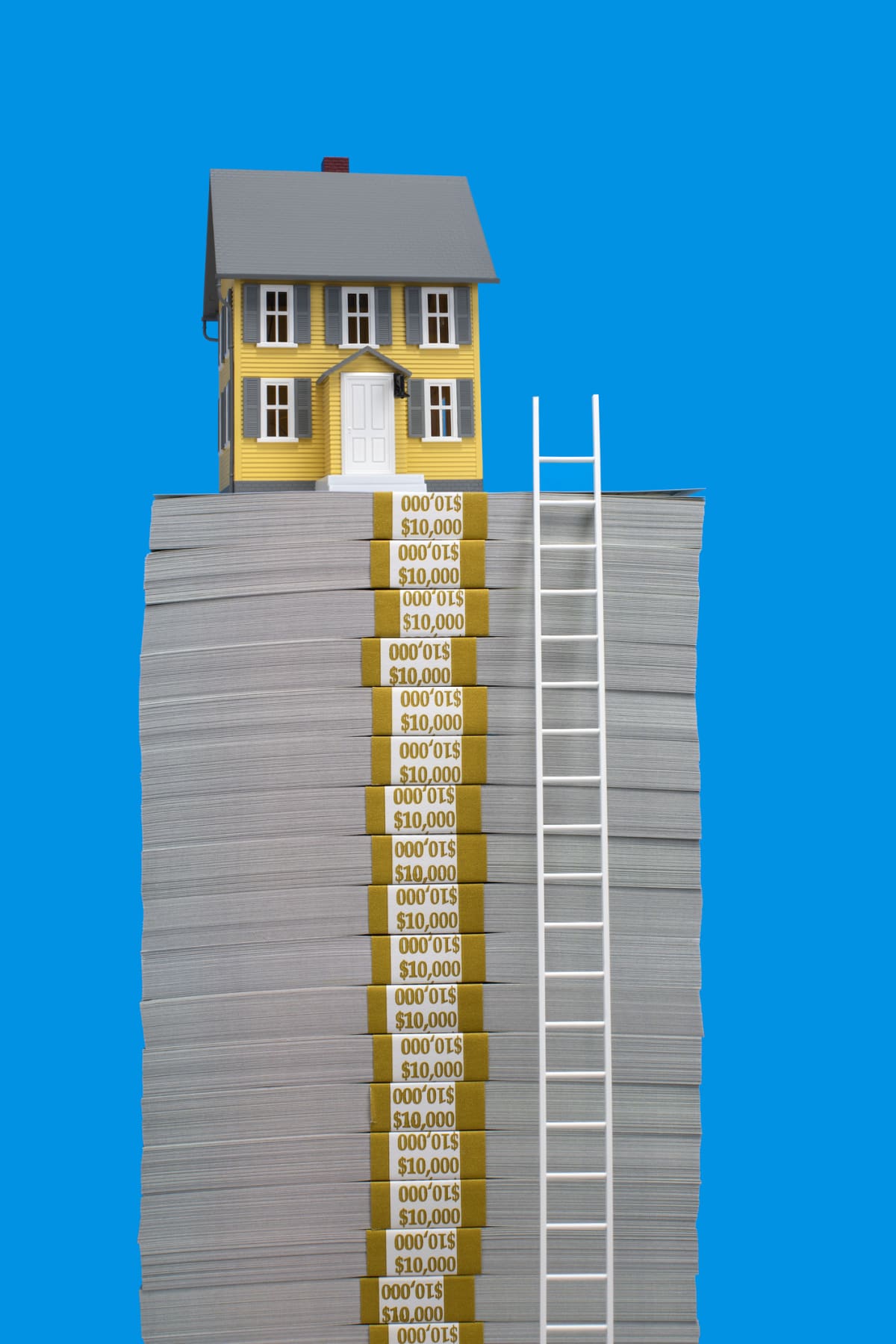 Model of yellow single family house sitting on top of stack of US $100 bill bundles with a ladder beside it, blue background