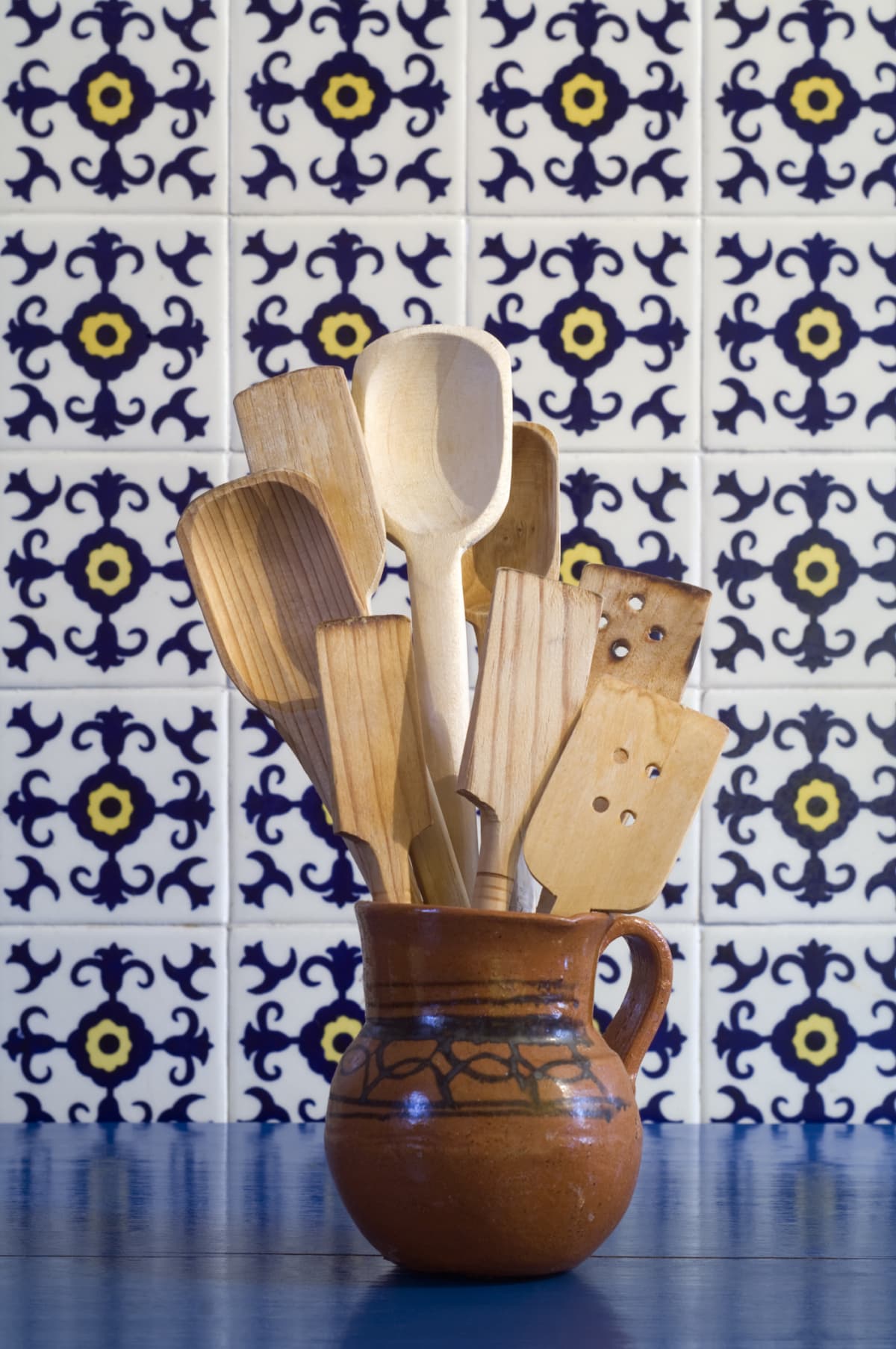 Wooden utensils in front of patterned tile