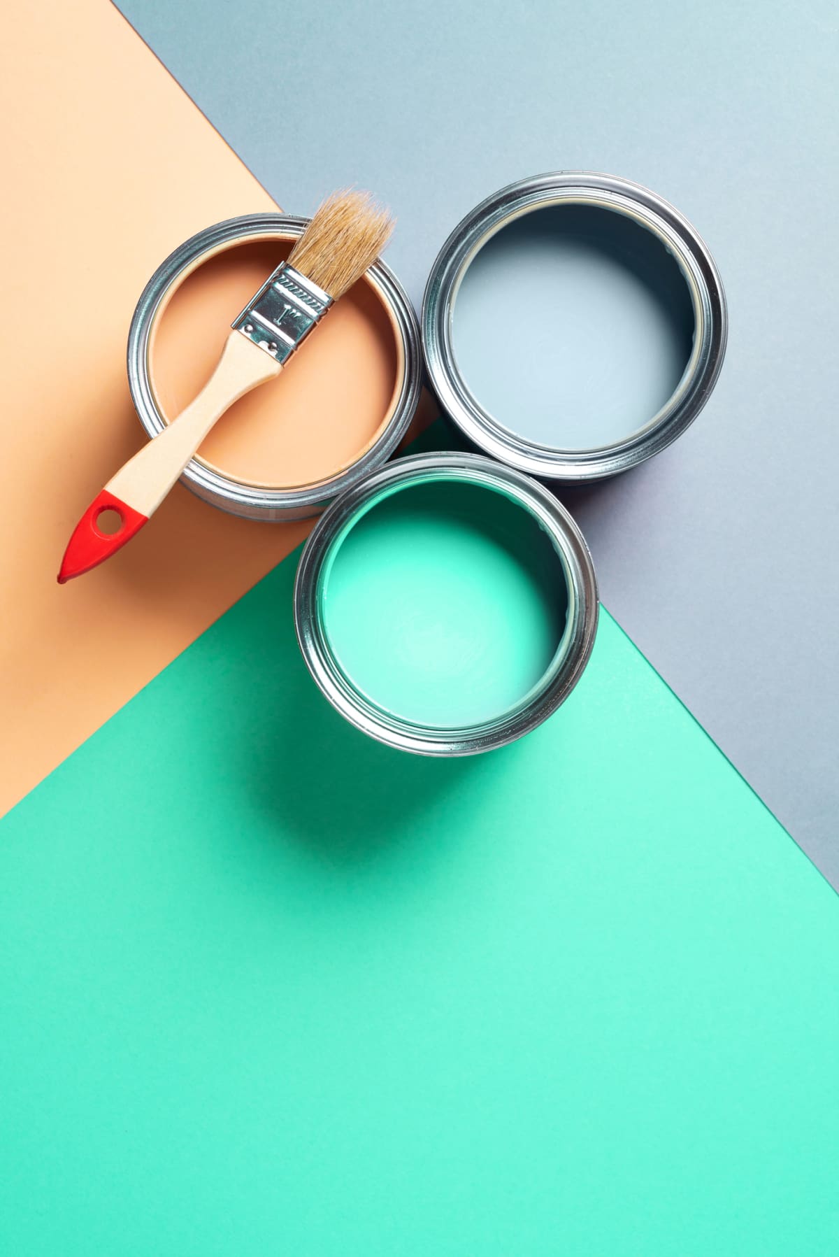Metal paint cans and paint brushes on multicolor background