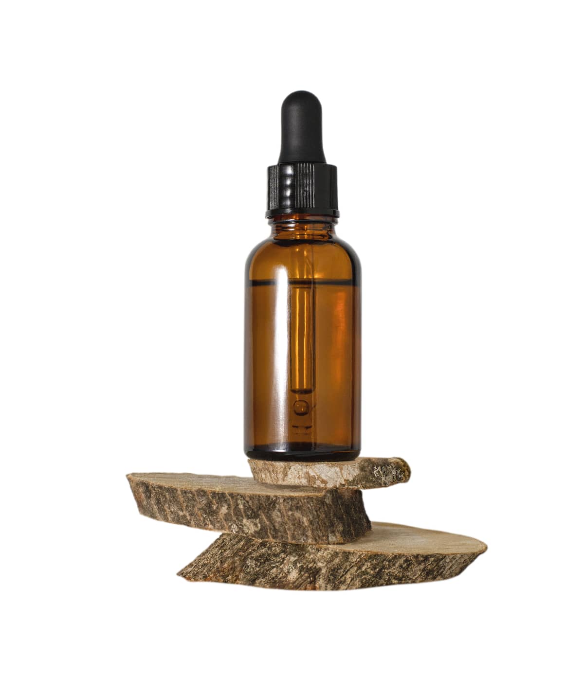 Dark brown glass bottle with facial serum or essential oil with dropper on wooden slices isolated on white background