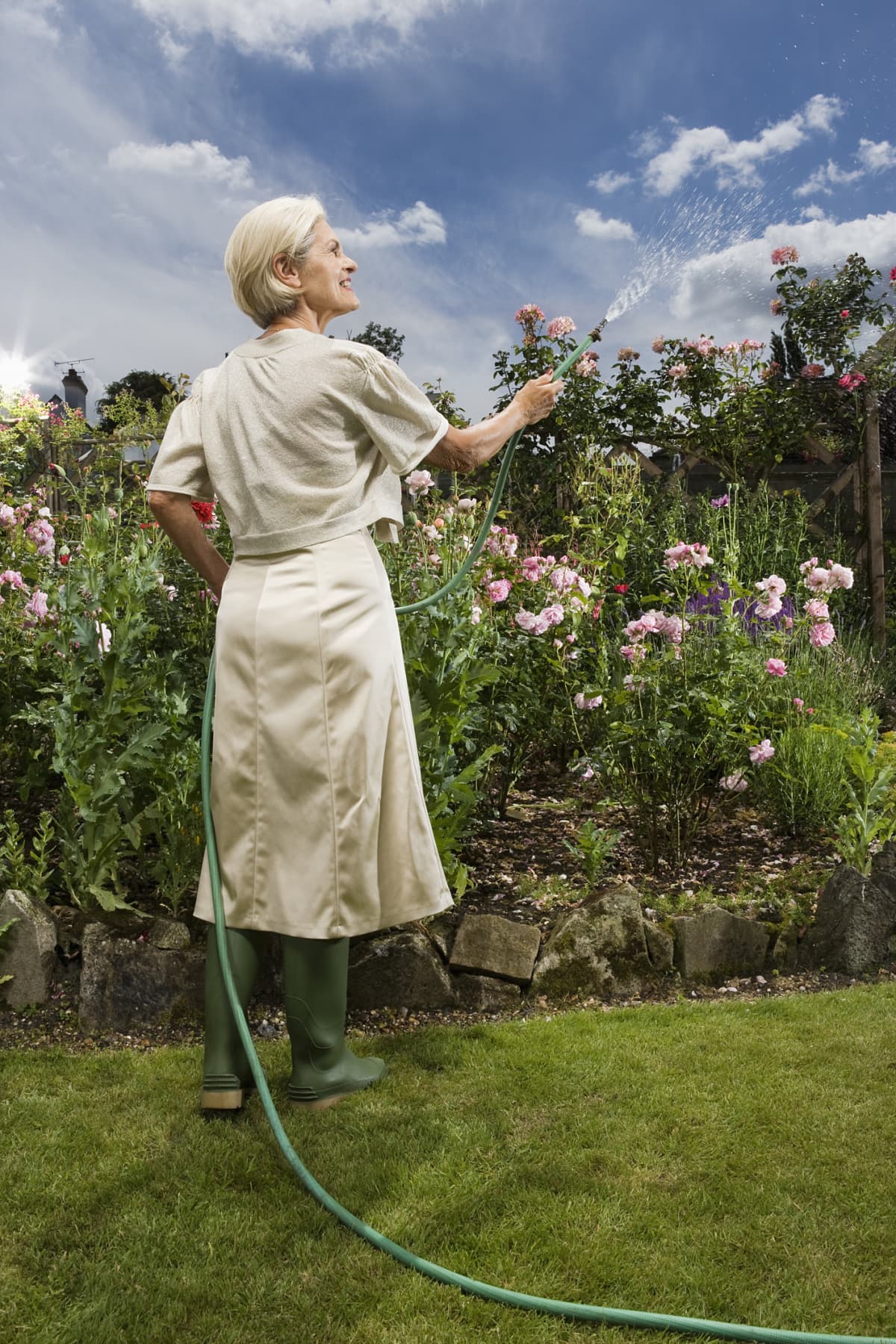 Woman watering flowers with hose