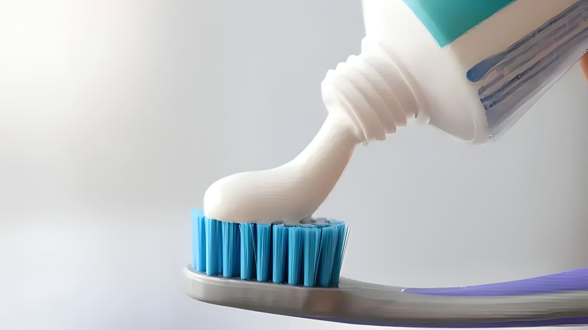 Pouring toothpaste onto a toothbrush