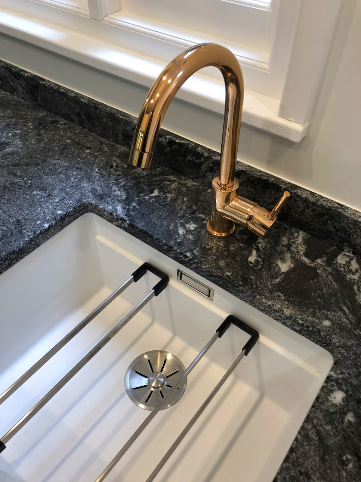 Modern kitchen with rectangular single bowl kitchen butler sink with victorian style bronze mixer tap, white ceramic sink with black granite worktop countertop