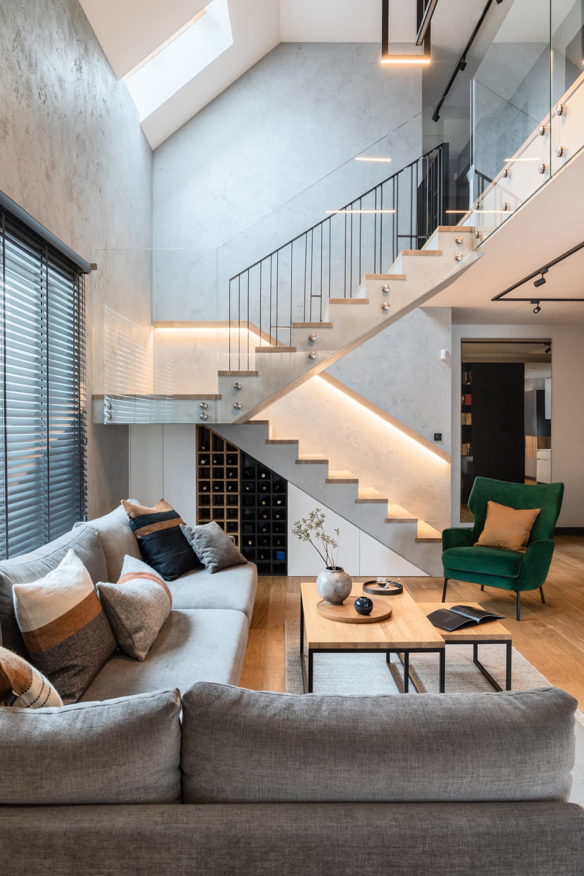 Stylish composition of stairs in living room interior, along with grey sofa, green velvet armchair, coffee table and minimalist personal accessories
