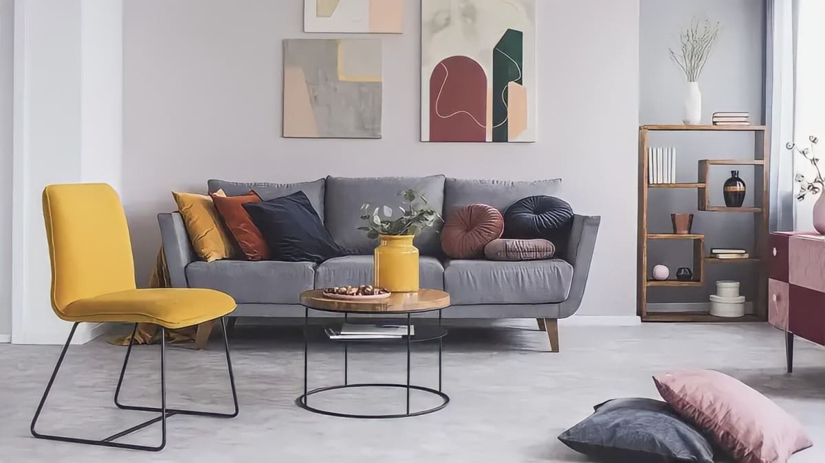 A living room with a couch, a table, and gray floors
