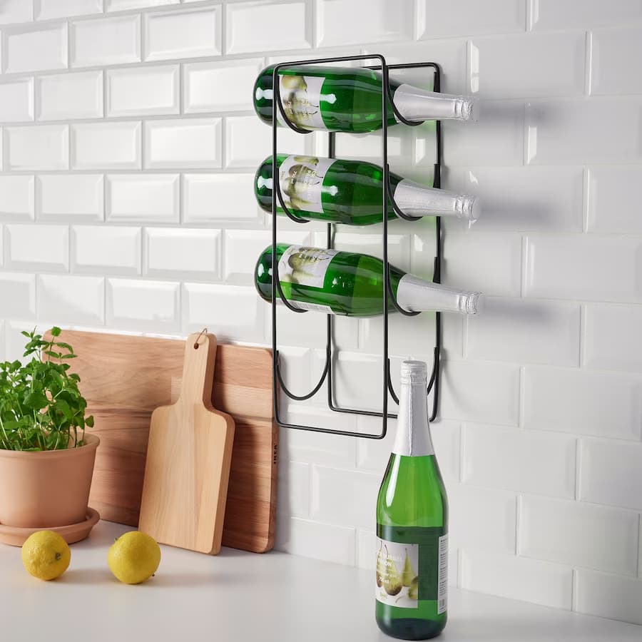 A wine rack with wine bottles above a kitchen counter.