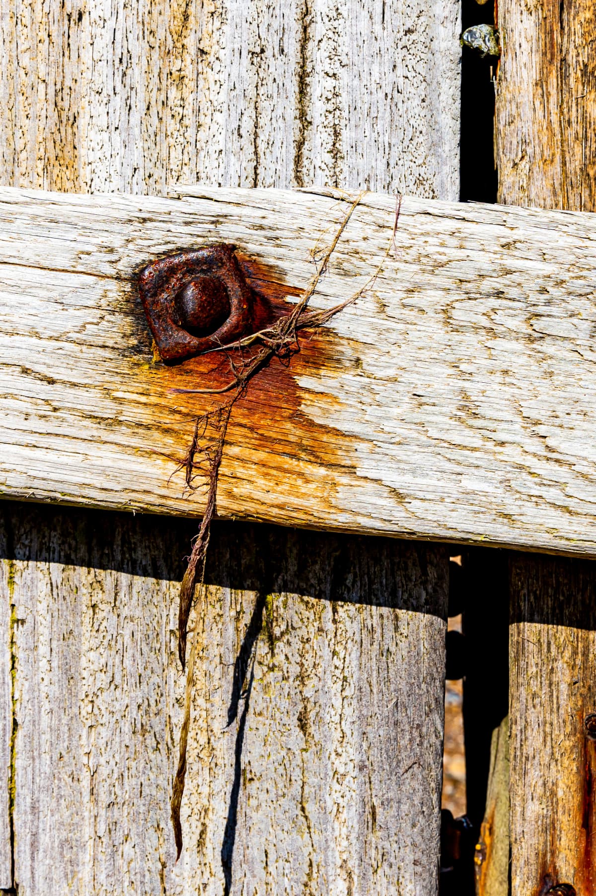 Weathered wooden posts and rusted bolts