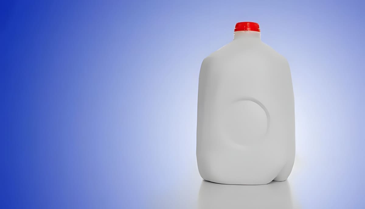 A plastic milk jug with a red lid